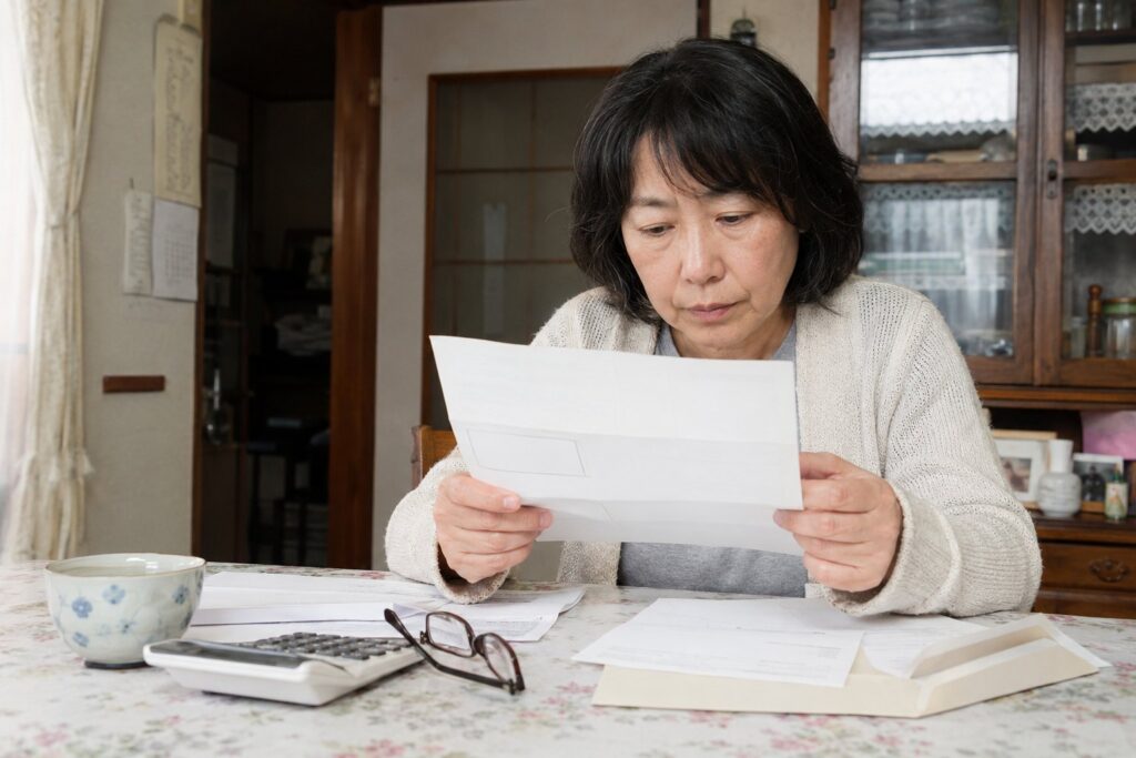 役所の窓口で封筒に入れた書類を提出する夫婦