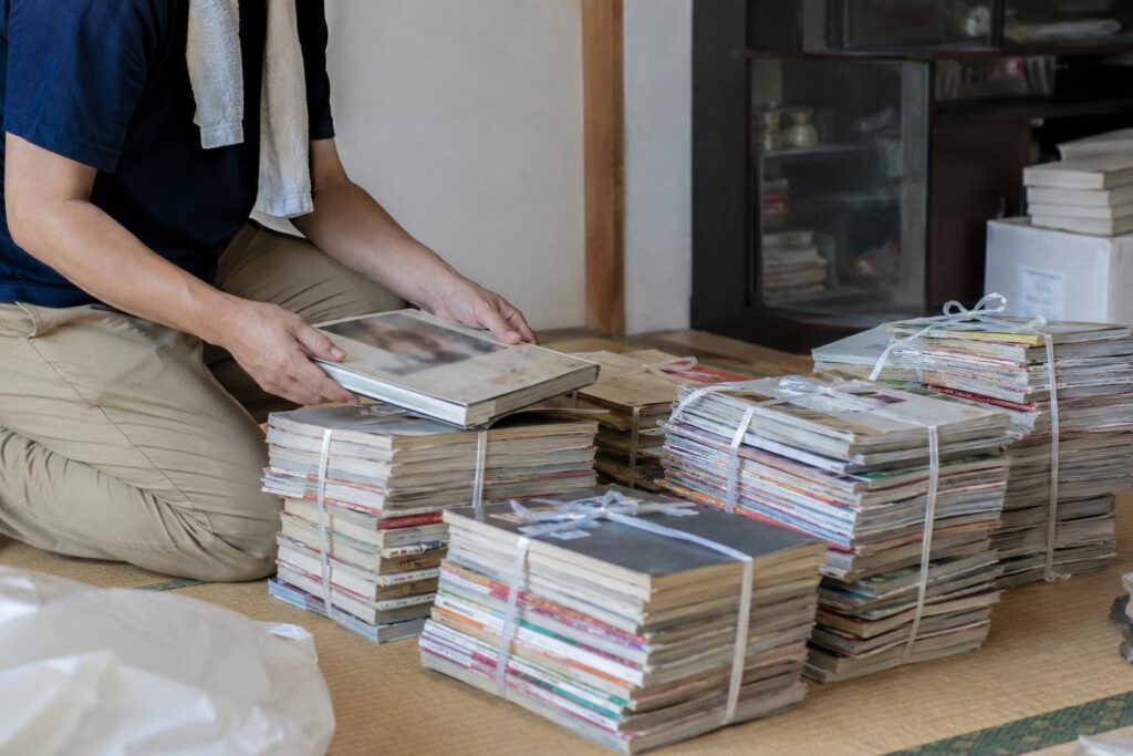 押し入れから出した着物や衣類を段ボールに詰める女性